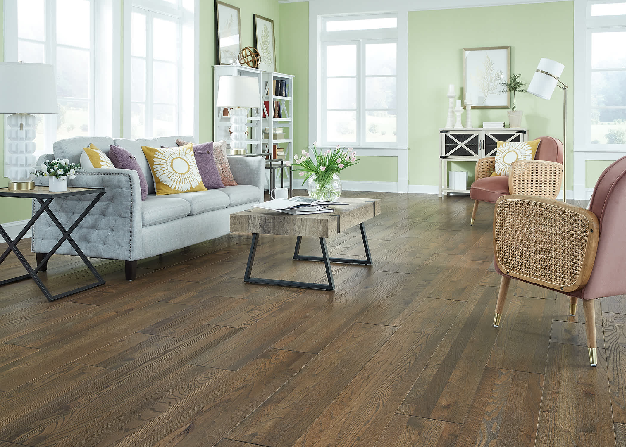 dark brown solid hardwood floor in living room with light green walls and gray sofa