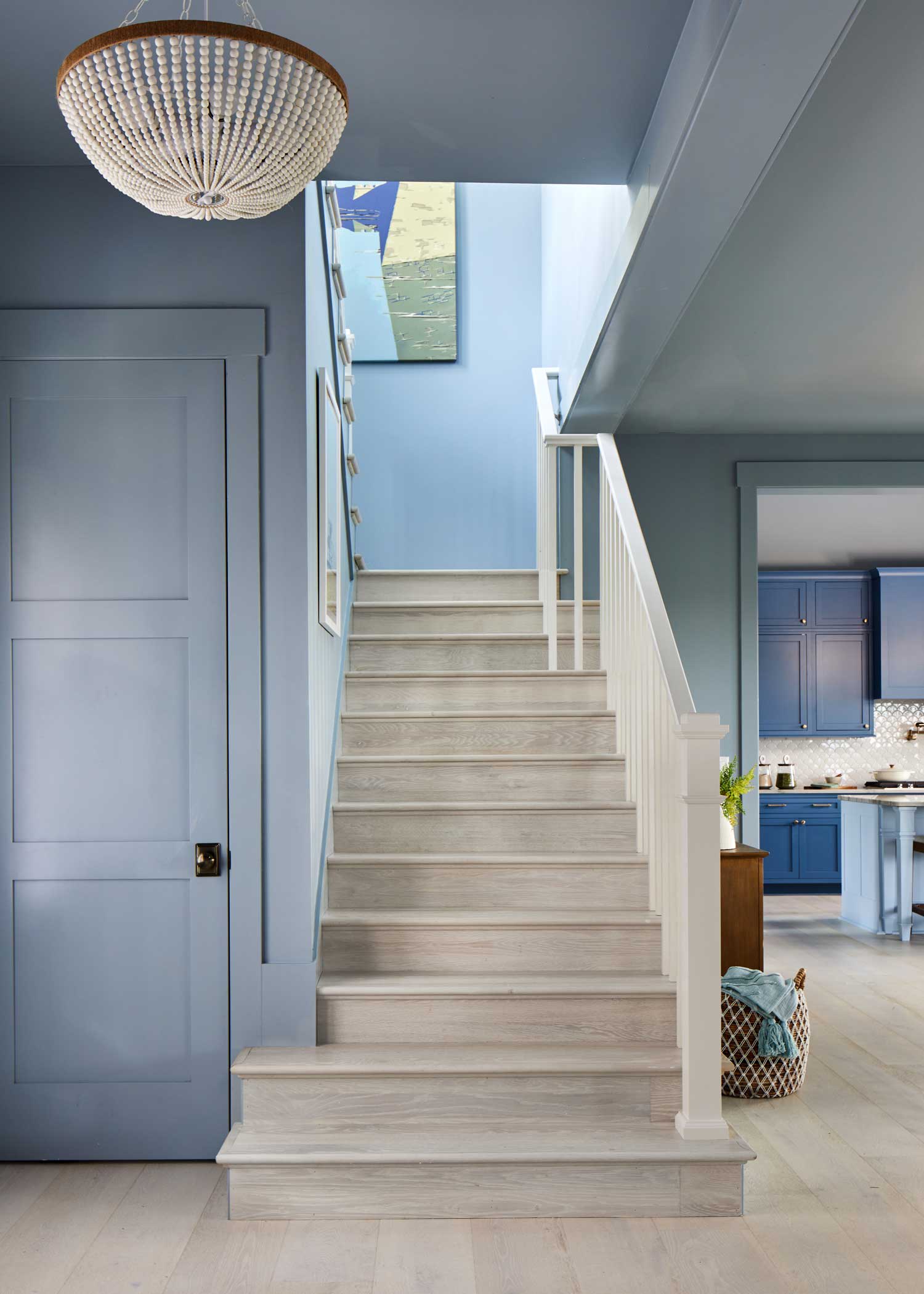 hgtv dream home 2024 living room with clearwater beach white oak engineered hardwood on custom stair treads and risers plus light blue walls and white beaded chandelier