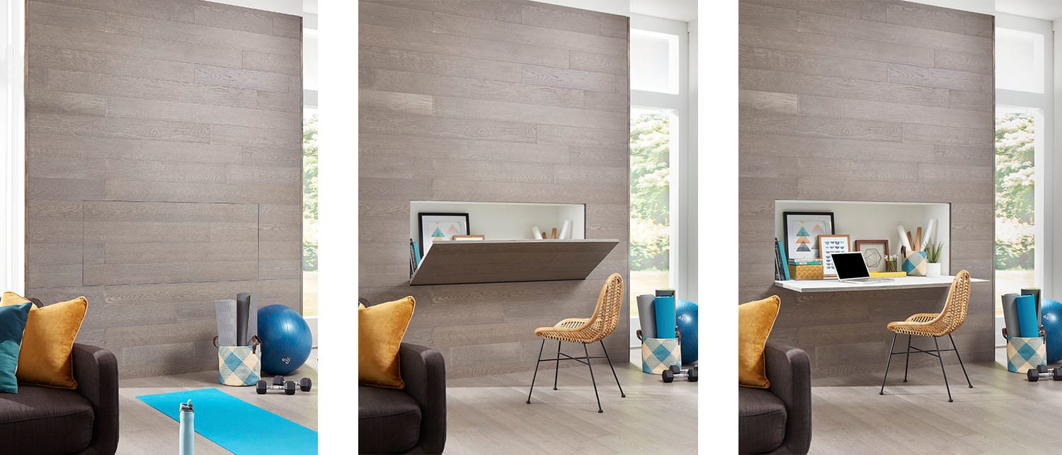 light gray hardwood floor on accent wall with built in hidden desk plus dark brown leather sofa and gold velvet pillow and turquoise yoga equipment