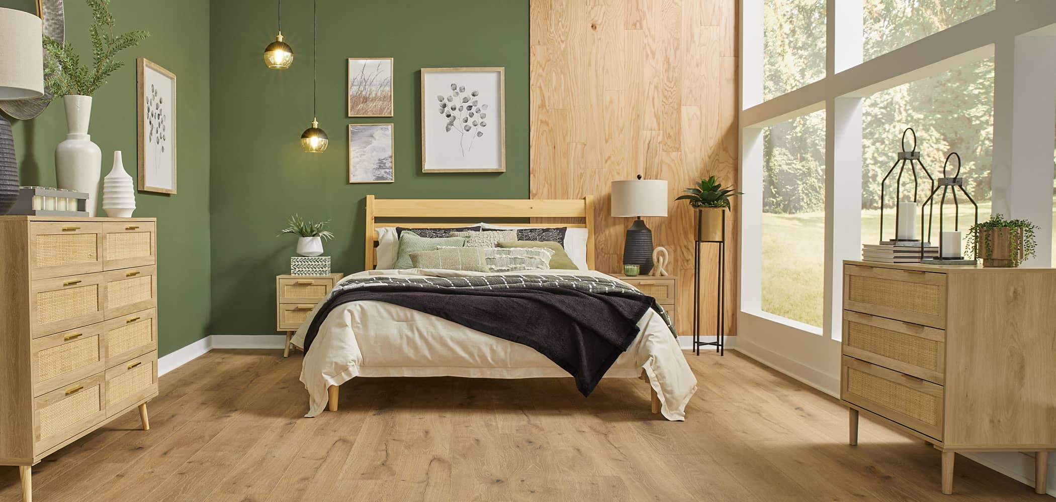 Light brown waterproof rigid vinyl plank floor in bedroom with green walls plus blonde wood accent wall and blonde wood bed with cream and brown bedding and blonde wood tables