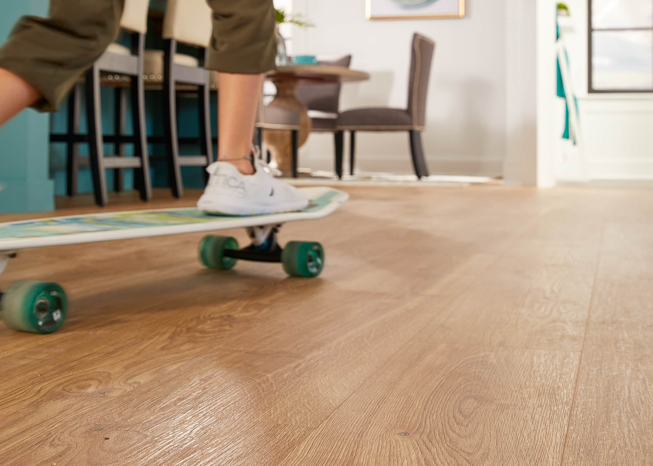 teen riding skateboard on light brown hybrid resilient waterproof floor