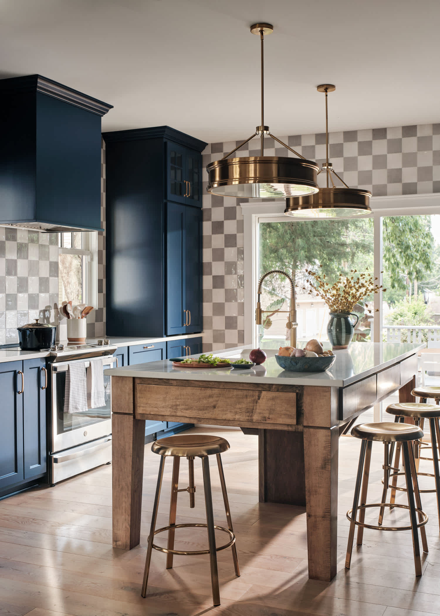 Valberg White Oak Engineered Hardwood Flooring in kitchen of HGTV 2023 Urban Oasis Home featuring dark blue floor to ceiling cabinets plus wood island with white countertop and checkered wallpaper
