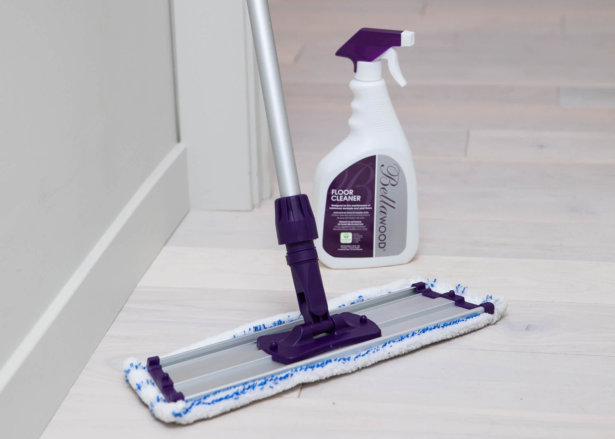 cleaning supplies including spray bottle and cleaning pad on mop