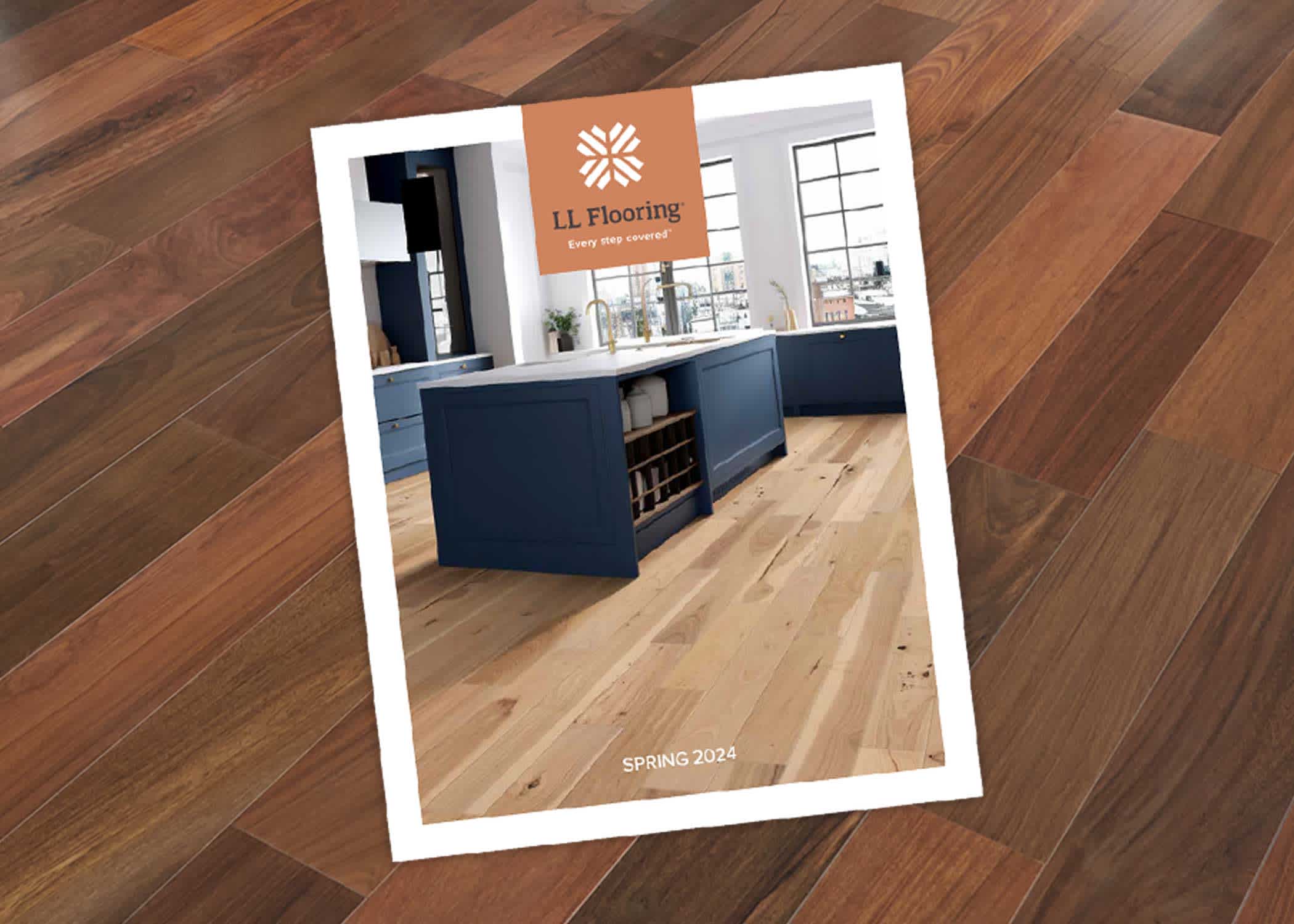 spring 2024 catalog cover with blonde wood engineered hardwood in kitchen with blue cabinets and white countertops on cover