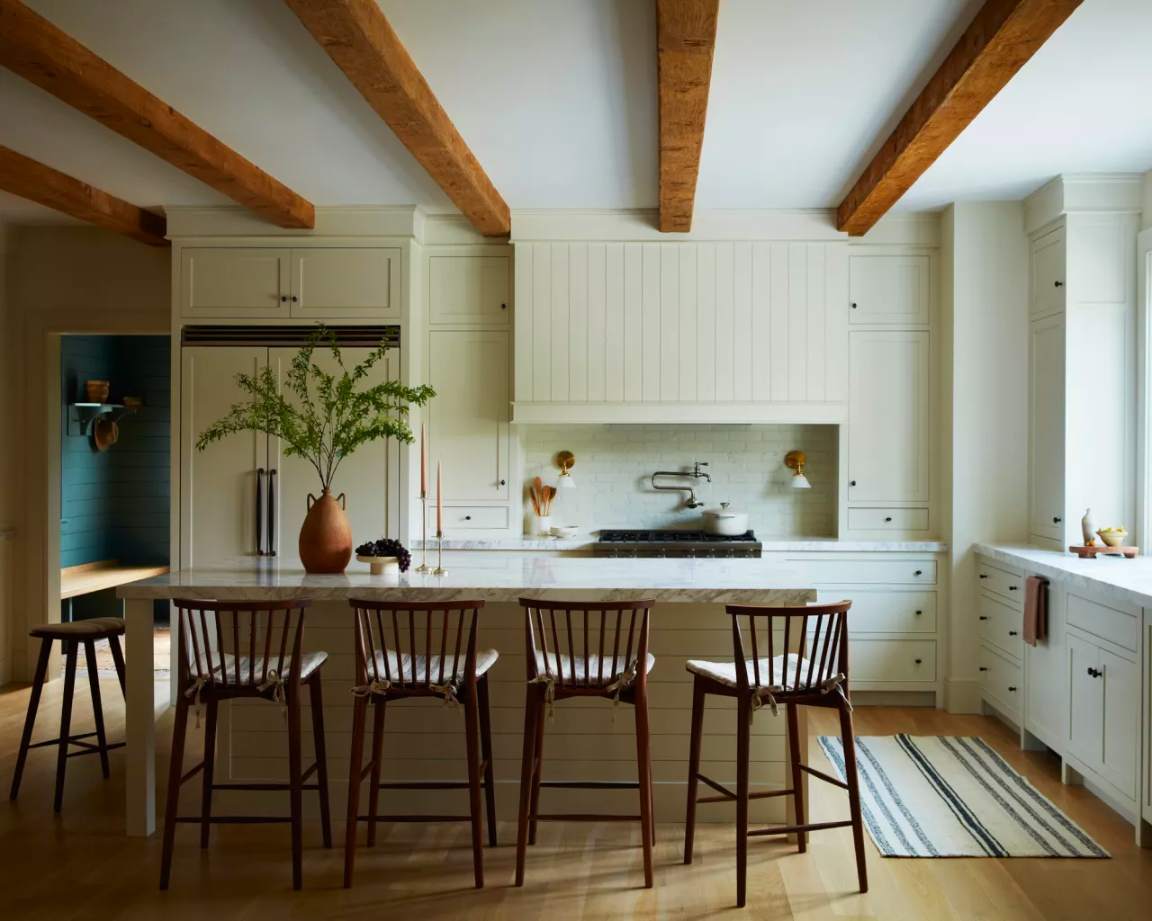 Kitchen with white cabinets and exposed wood beams on ceiling