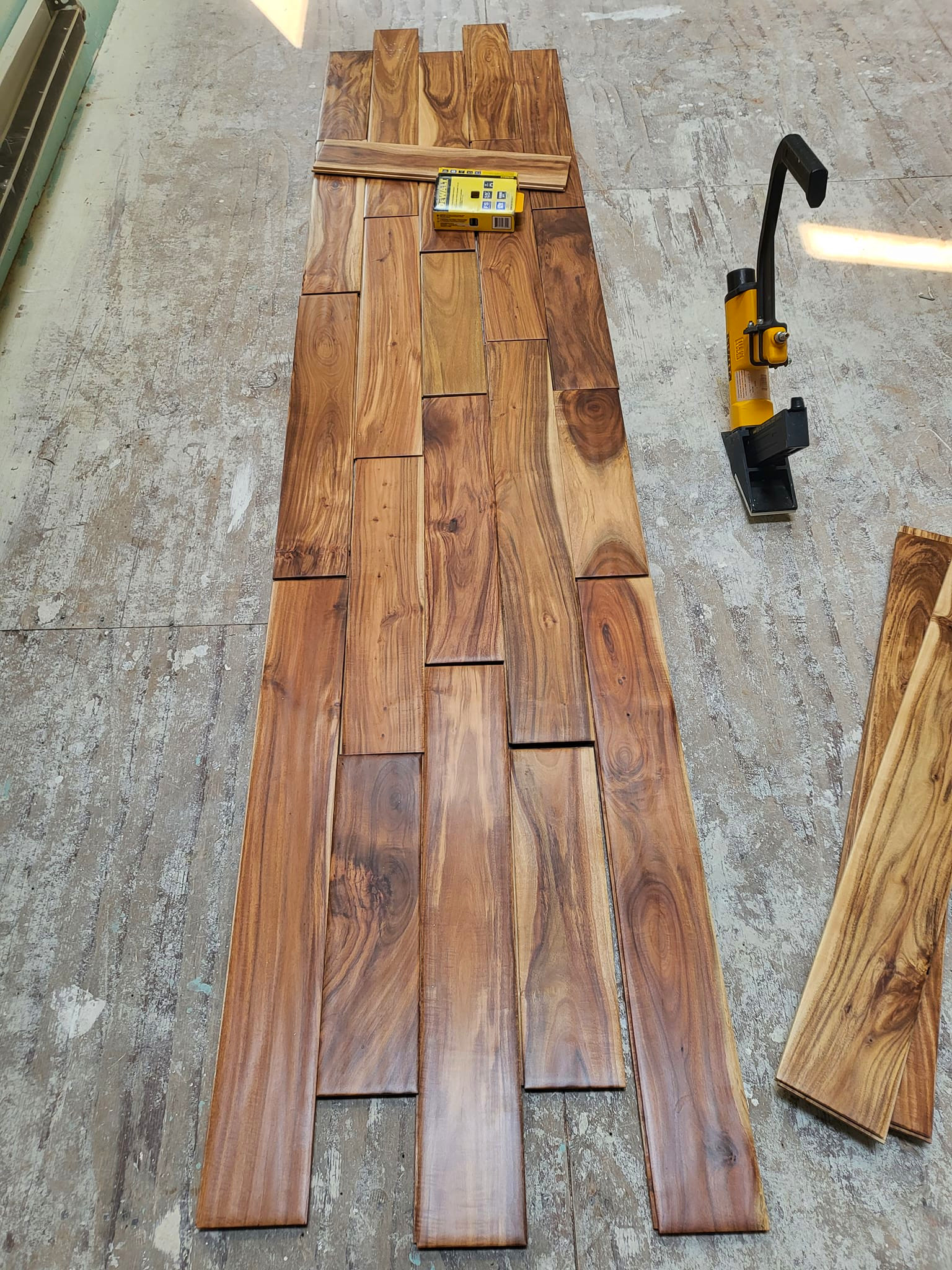 some planks mid install of close up of Tobacco Road Acacia hardwood flooring from ll flooring