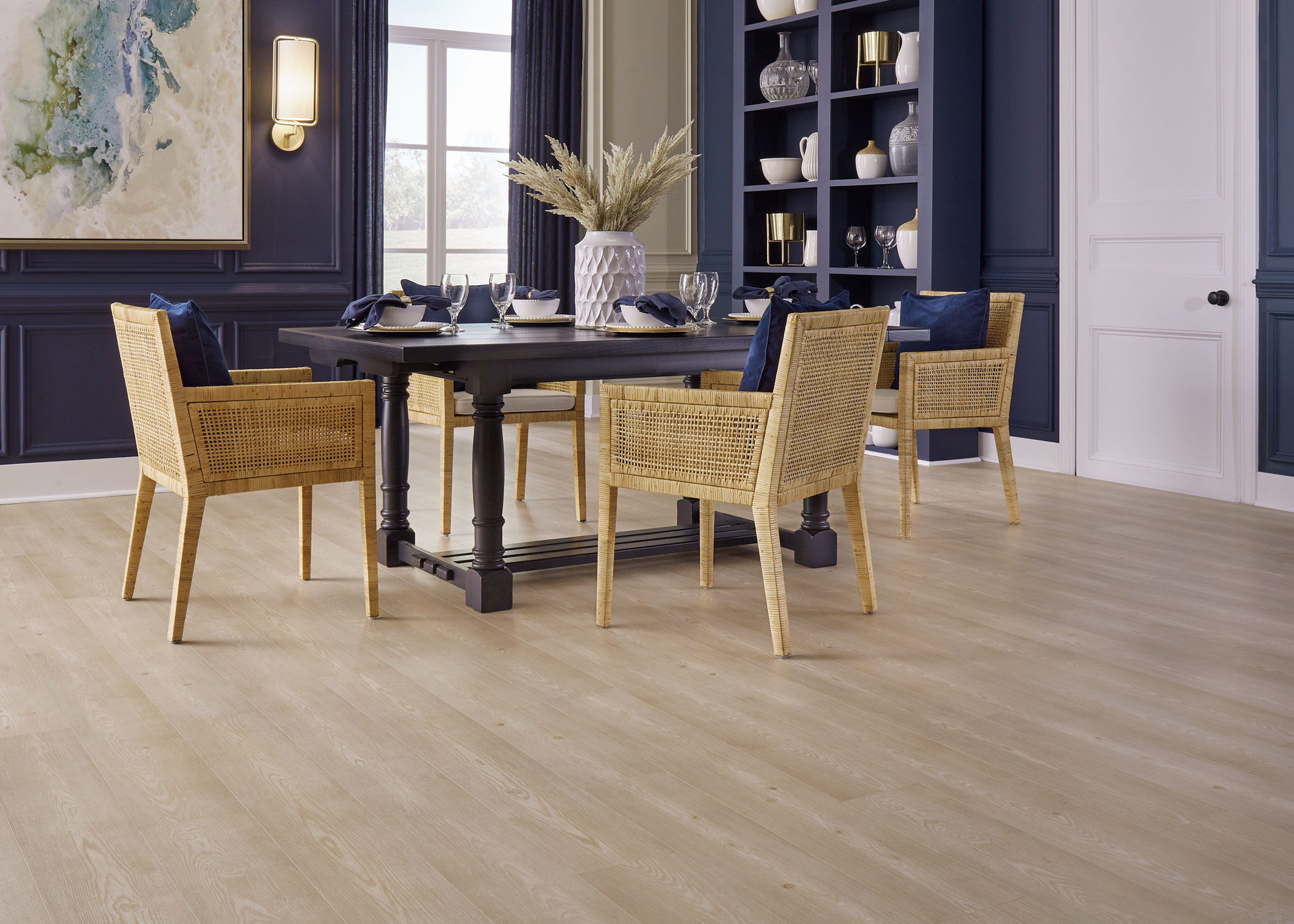 blonde waterproof hybrid resilient floor in dining room with dark blue walls plus dark brown dining table and blonde wood rattan chairs