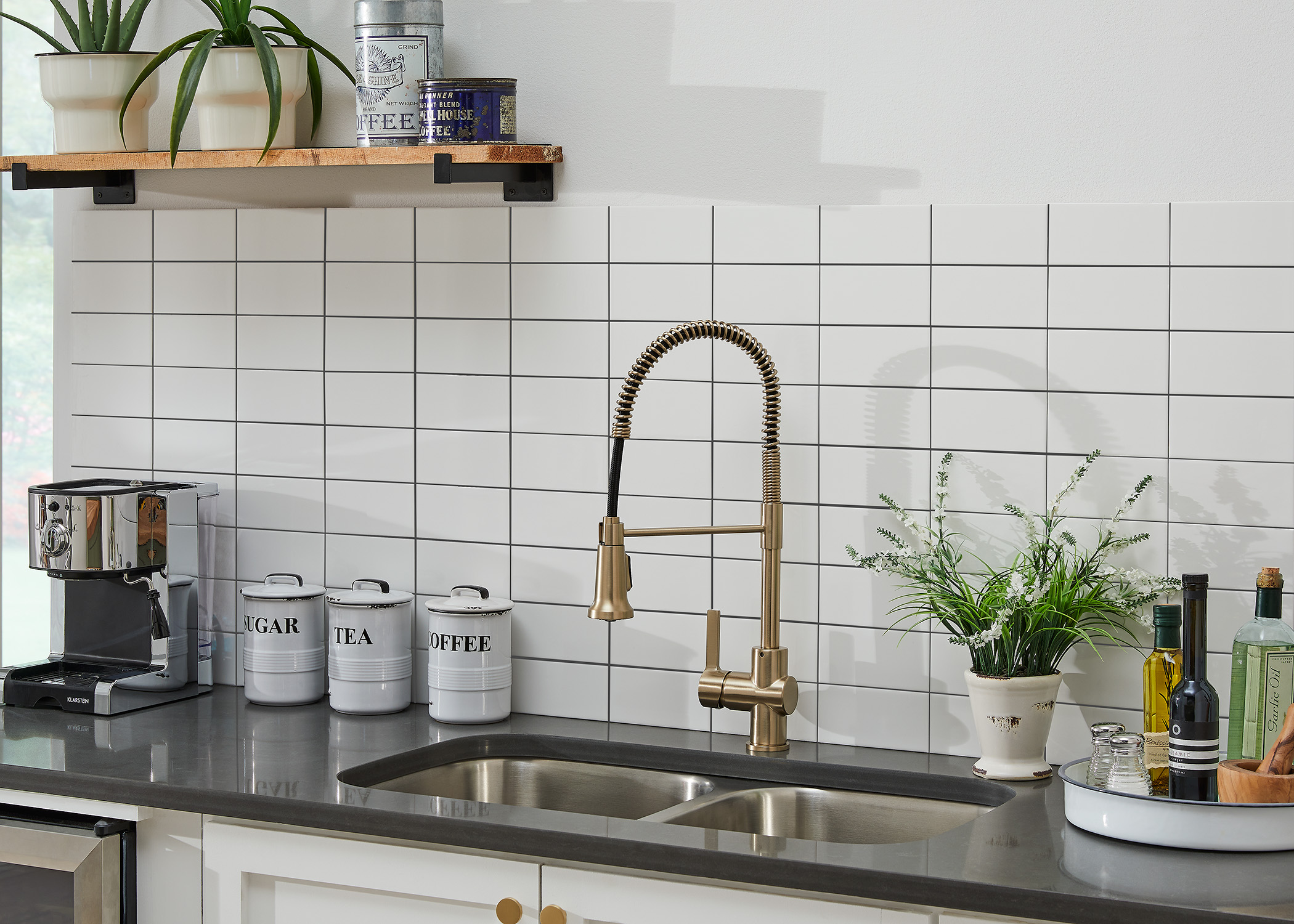 white subway tile in kitchen with brass faucet and dark granite countertops