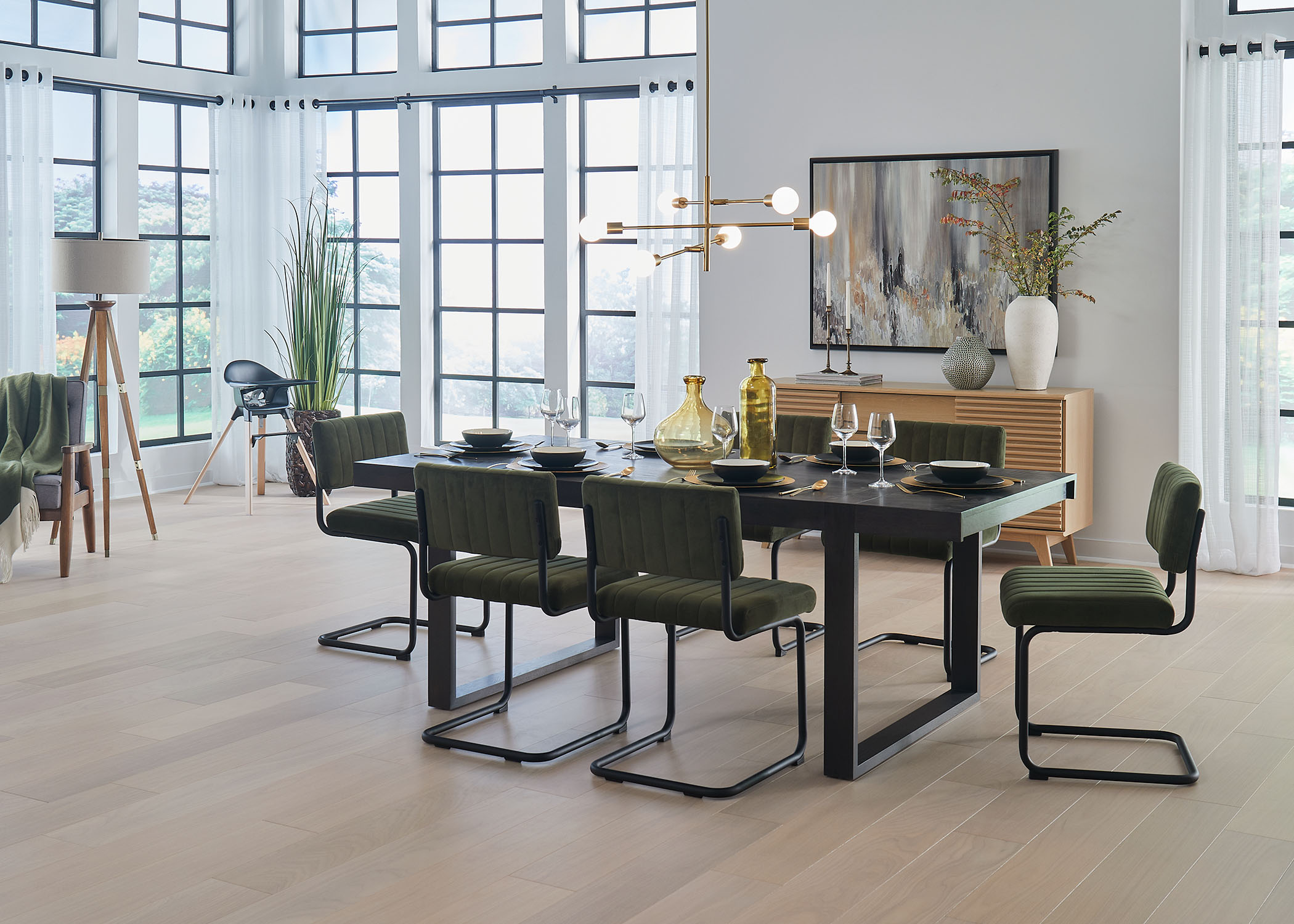 light blonde engineered hardwood floor in dining room with black dining table and black and green dining chairs plus blonde wood credenza and white sheers