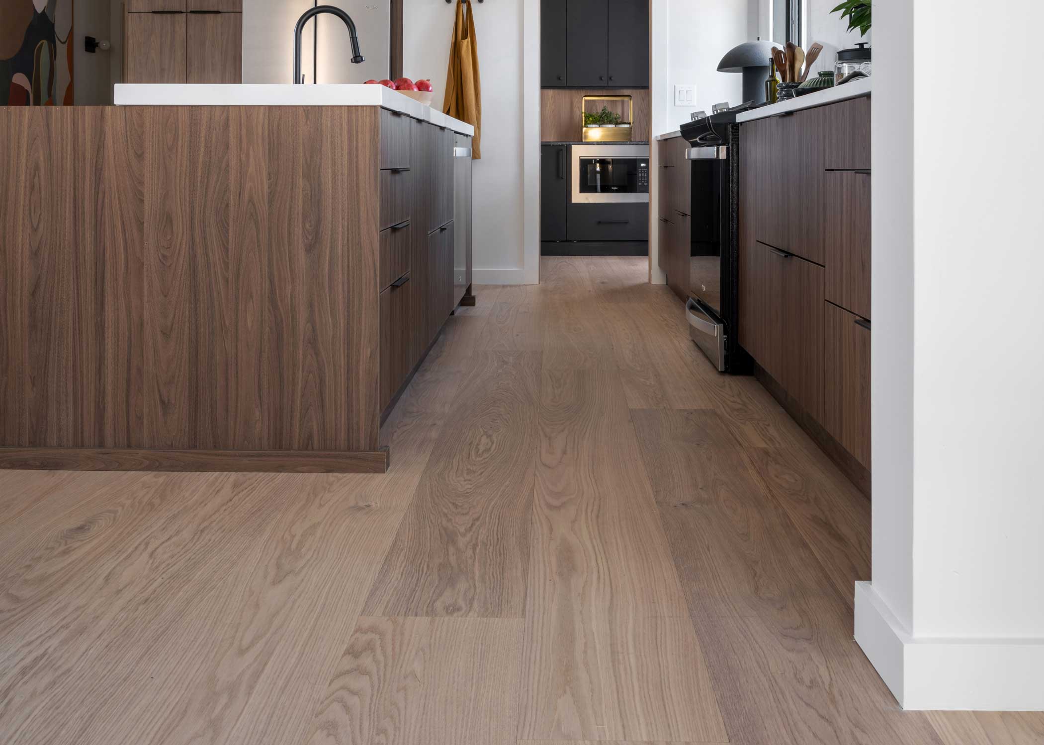 Lagan River White Oak Engineered Hardwood Flooring 2024 HGTV Smart Home kitchen with dark brown cabinetry and white countertops plus flooring installed as backsplash