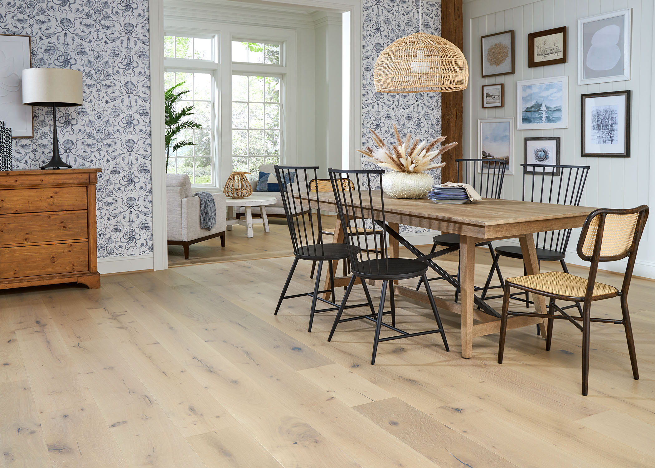 blonde engineered hardwood flooring in dining room with blonde wood table with black spindle chairs plus blue and white wallpaper and blue and white artwork