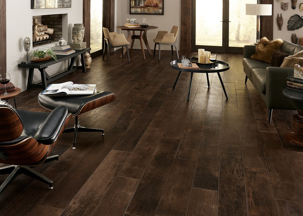 48 in. x 8 in. Smoked Whiskey Oak Porcelain Tile in office with black leather sofa plus black leather recliner with dark brown wood accents and small table with two chairs