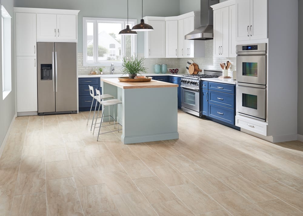 24 in. x 12 in. Marbella Ivory Porcelain Tile in kitchen with blue lower cabinets and white upper cabinets plus large pale blue island with butcher block counter and two white stools