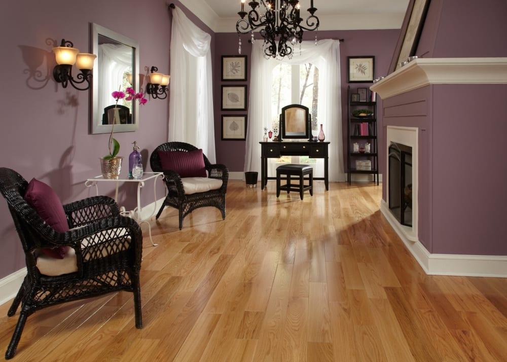 3/4 in. x 5 in. Character Red Oak Solid Hardwood Flooring in sitting room with black wood vanity plus black wicker chairs and dark purple walls
