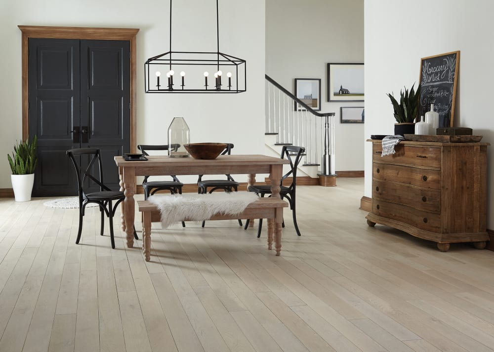.75 in. x 5 in. Vineyard Sound Oak Solid Hardwood Flooring in dining room with wood table and bench seat plus black dining chairs with wrought iron chandelier above and rustic dresser with decorative items on top