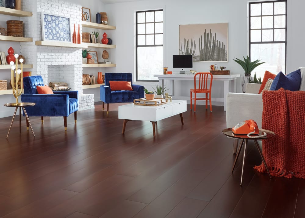 Cabernet Extra Wide Plank Engineered Bamboo Flooring in living room with royal blue velvet chairs plus beige upholstered sofa with orange throw and white desk with orange metal chair