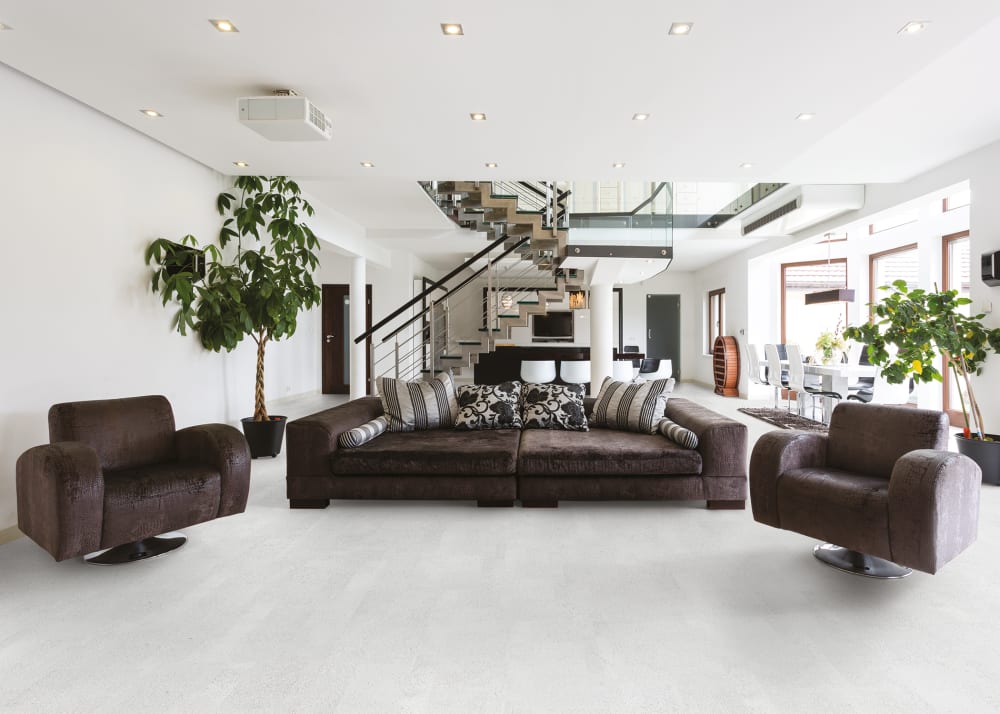 Apollo Cork Flooring in living room with dark brown leather furniture and oversized faux plant