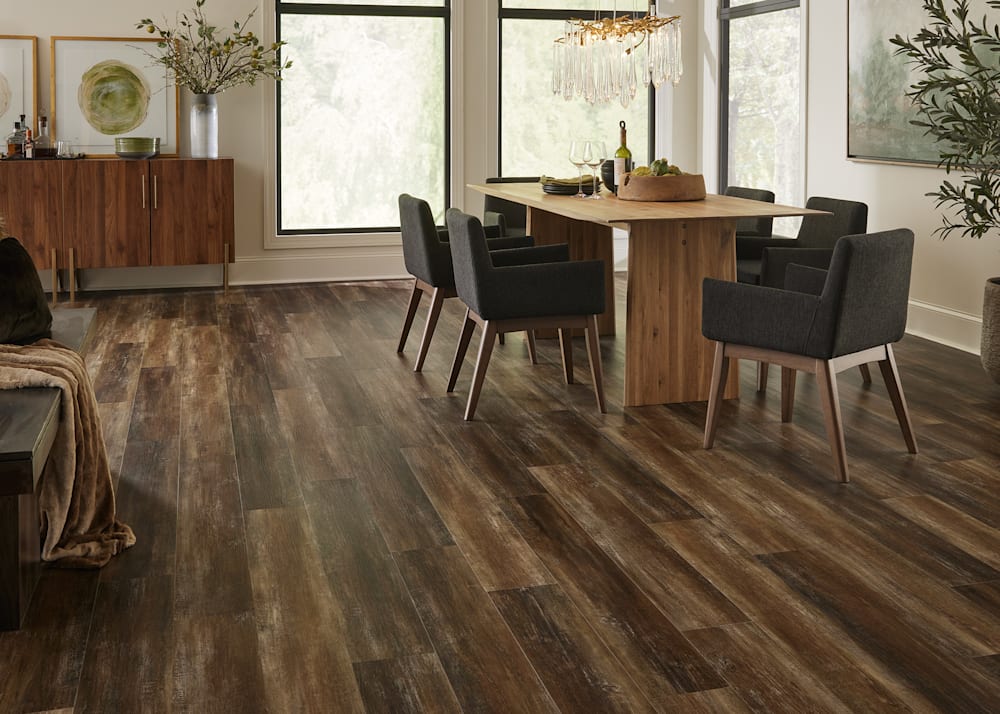 7mm+Pad Copper Barrel Oak Rigid Vinyl Plank Flooring in dining room with dark brown fabric chairs and light wood dining table plus gold twig and teardrop chandelier