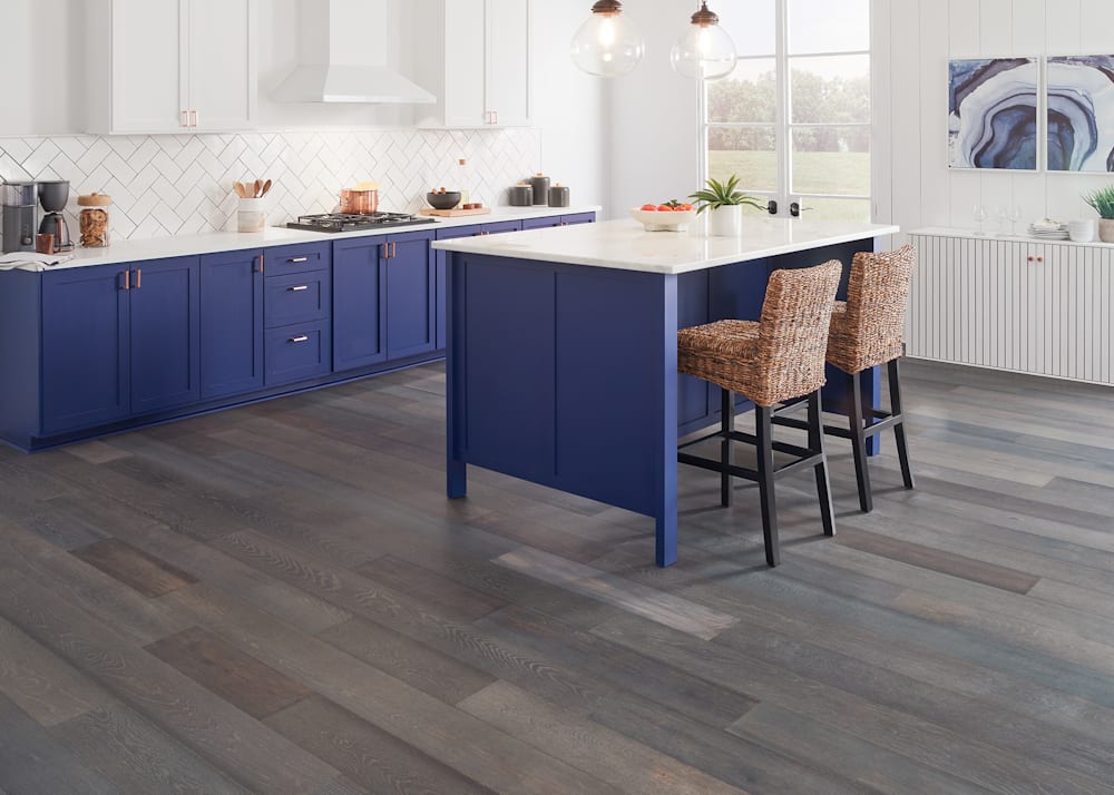 7mm+Pad x 7.5 in Earl Gray White Oak Water-Resistant Engineered Hardwood Flooring in kitchen with royal blue island and lower cabinets plus white countertops and white upper cabinets