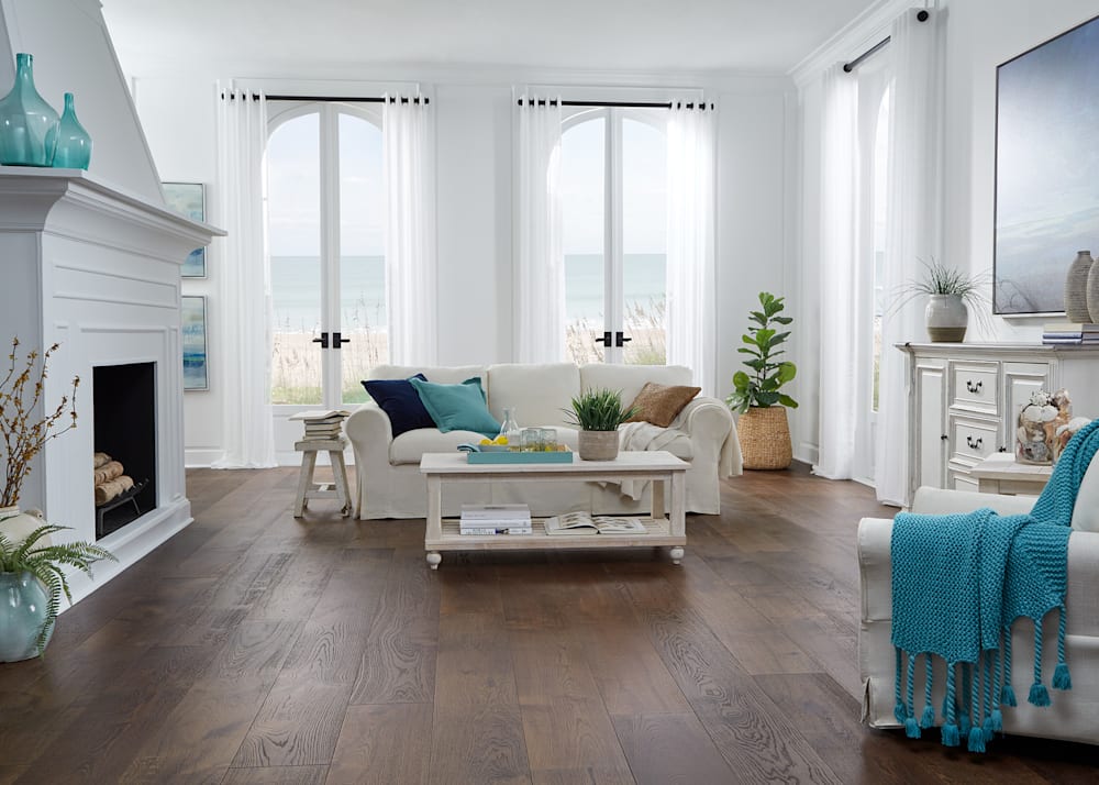 5/8 in x 9-1/2 in Rockaway Beach White Oak Distressed Engineered Hardwood Flooring in living room with white furniture and turquoise accents
