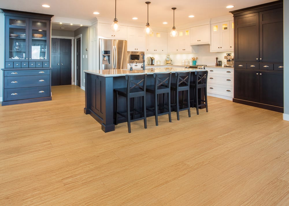 7mm+Pad x 7.5 in Natural Strand Water-resistant Engineered Bamboo Flooring in traditional kitchen with dark island and white cabinets