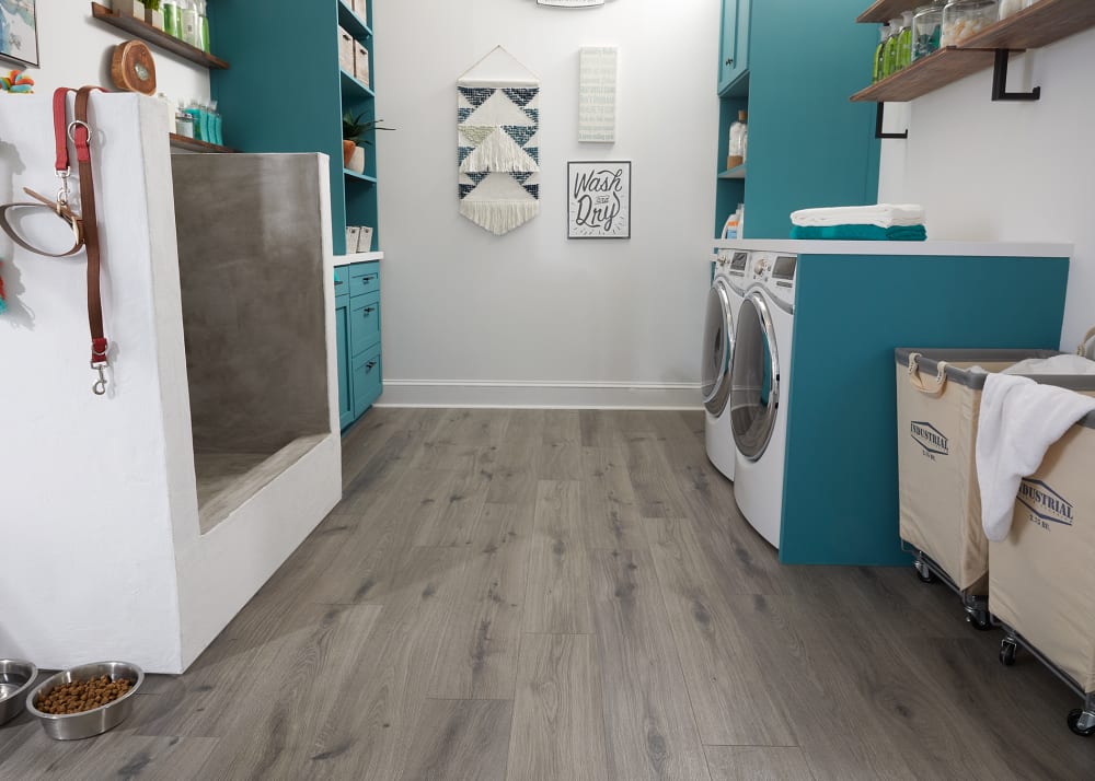 7mm+Pad Silk Spire Oak Hybrid Resilient Flooring in laundry room with dog washing station plus turquoise cabinets and white washer and dryer