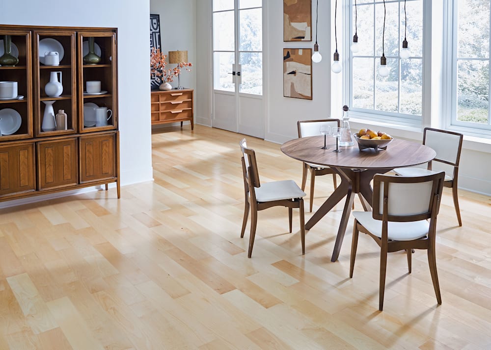 3/8 in x 5 in Natural Maple Engineered Hardwood Flooring in dining room with dark wood dining table and chairs plus wood hutch and string bulb chandelier