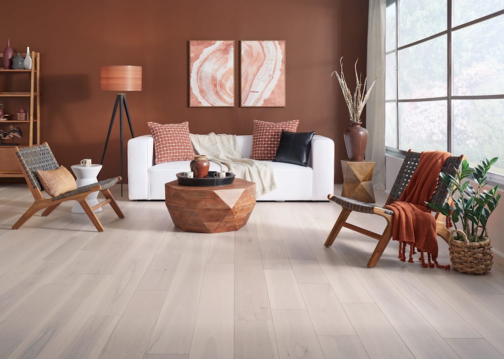1/2 in x 7.4 in Glacier Creek Hickory Distressed Engineered Hardwood Flooring in living room with dark brown walls plus white sofa and diamond shaped dark brown wood coffee table