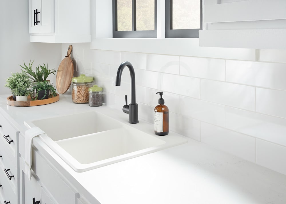 4 in x 12 in Vivid White Subway Ceramic Tile in kitchen behind white black faucet plus white ceramic sink with soap dispenser