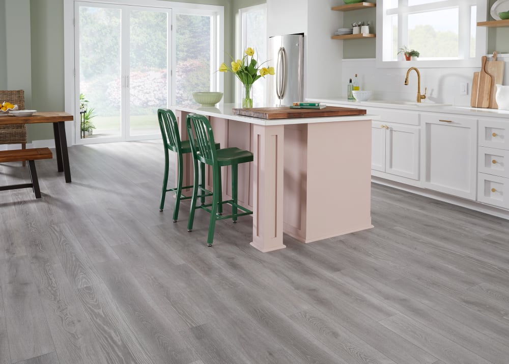 5mm+Pad Sheffield Oak Rigid VInyl Plank Flooring in kitchen with pale pink island and dark green chairs