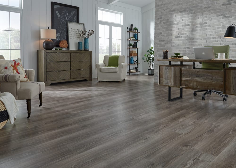 8mm+Pad Mountain Trail Oak Waterproof Laminate Flooring in contemporary kitchen with black appliances and island in office with dark brown desk and beige fabric chairs and brick wall