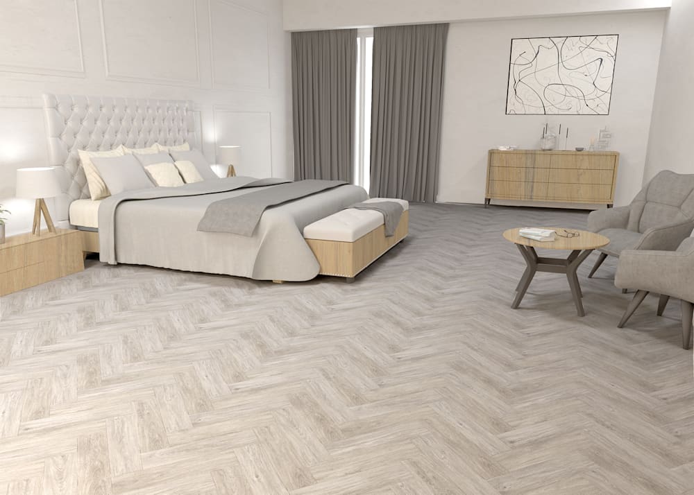 12mm w/pad Hollywood Herringbone Waterproof Laminate Flooring in bedroom with white upholstered headboard plus beige bedding with dark beige accent chairs and small round coffee table and light wood dresser