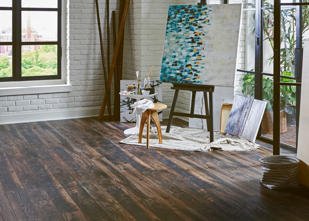 12mm Antique Acres Oak Waterproof Laminate Flooring in art studio with easel and small wooden bench