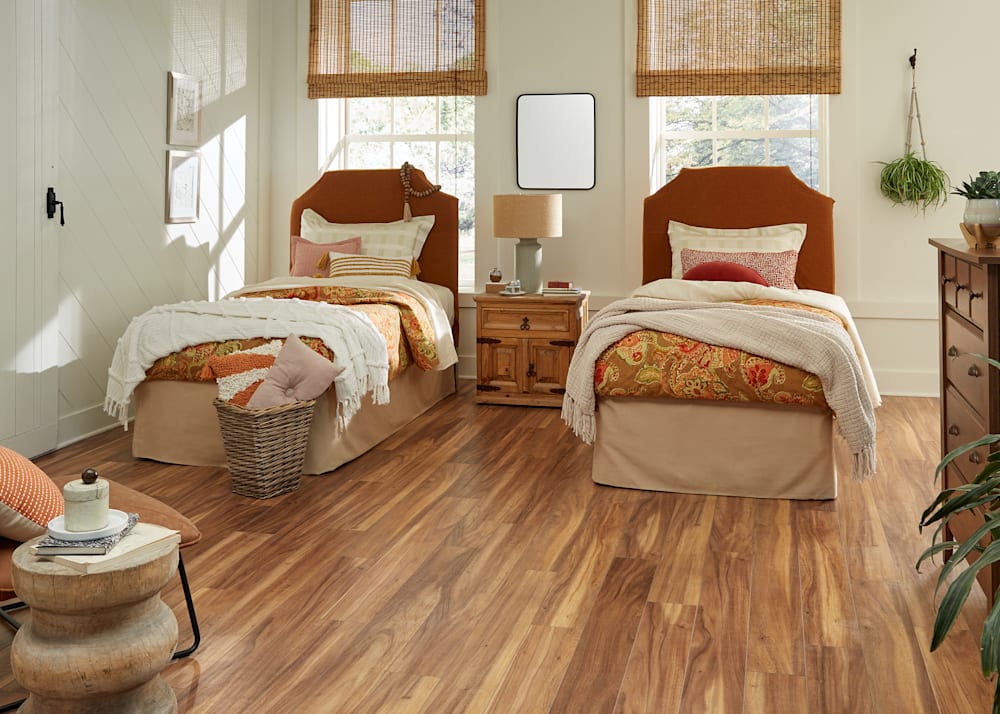 12mm+Pad Tobacco Road Acacia Waterproof Laminate Flooring in bedroom with two twin beds and rust colored headboards