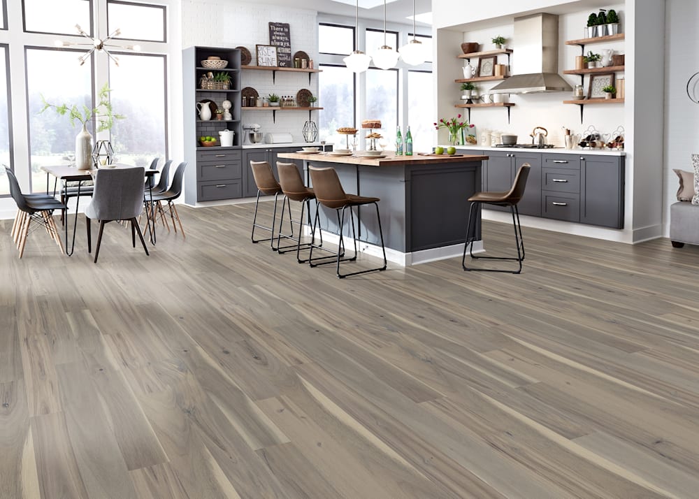 3/4 in. x 4.75 in. Pearl Sands Acacia Solid Hardwood Flooring in kitchen with dark gray cabinets plus island with butcher block top and dining table with black dining chairs