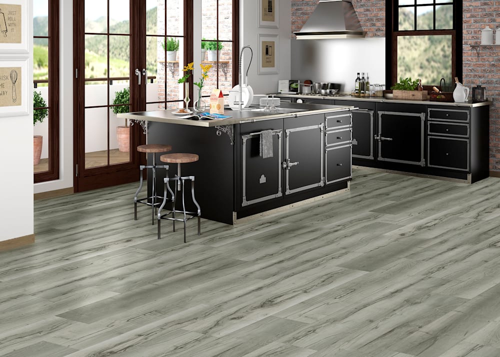 6mm with pad Andes Maple Rigid Vinyl Plank Flooring in kitchen with black cabinets with metal accents and brick accent wall plus oversized island with two industrial style stools and French doors leading to outside porch