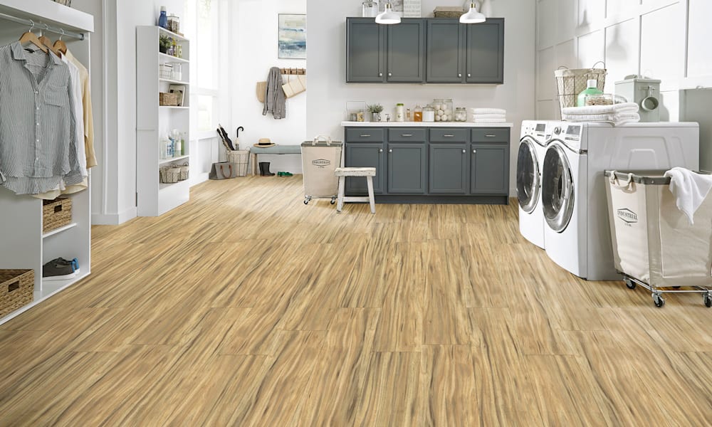 7mm with pad Sweet Plain Acacia Rigid Vinyl Plank Flooring in laundry room with dark gray cabinets plus white washer and dryer and drying rack with storage