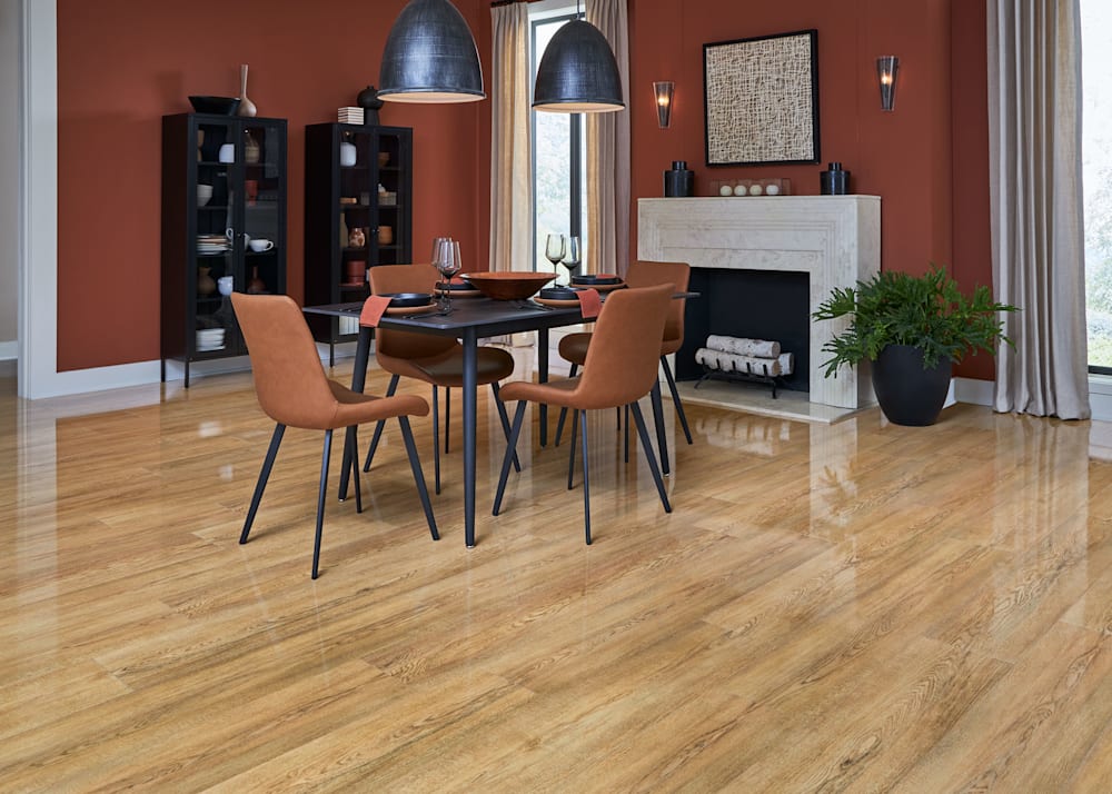 12mm with Pad Stillwater Oak Waterproof Laminate Flooring in dining room with dark reddish brown walls and black table with armless fabric chairs and black dining lights and limestone fireplace