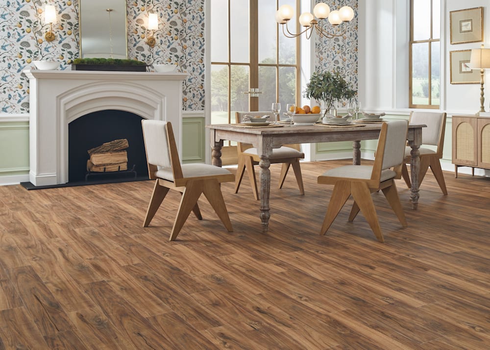 5mm with Pad Gilded Teak Waterproof Rigid Vinyl Plank Flooring in dining room with wallpaper plus distressed wood dining table and beige upholstered chairs and white fireplace and wall sconces