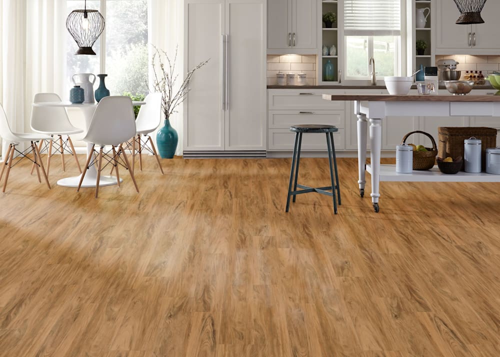 5mm w/Pad Lafayette Koa Waterproof Rigid Vinyl Plank Flooring in kitchen with white cabinets and dark wood countertops plus freestanding island and white tulip table with chairs
