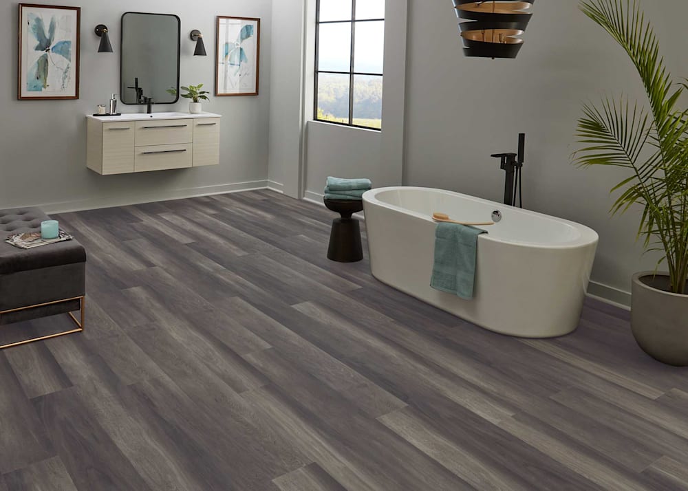6mm with Pad Stormy Glen Oak Rigid Vinyl Plank Flooring in bathroom with oval freestanding tub and black fixtures plus gray walls and black chandelier