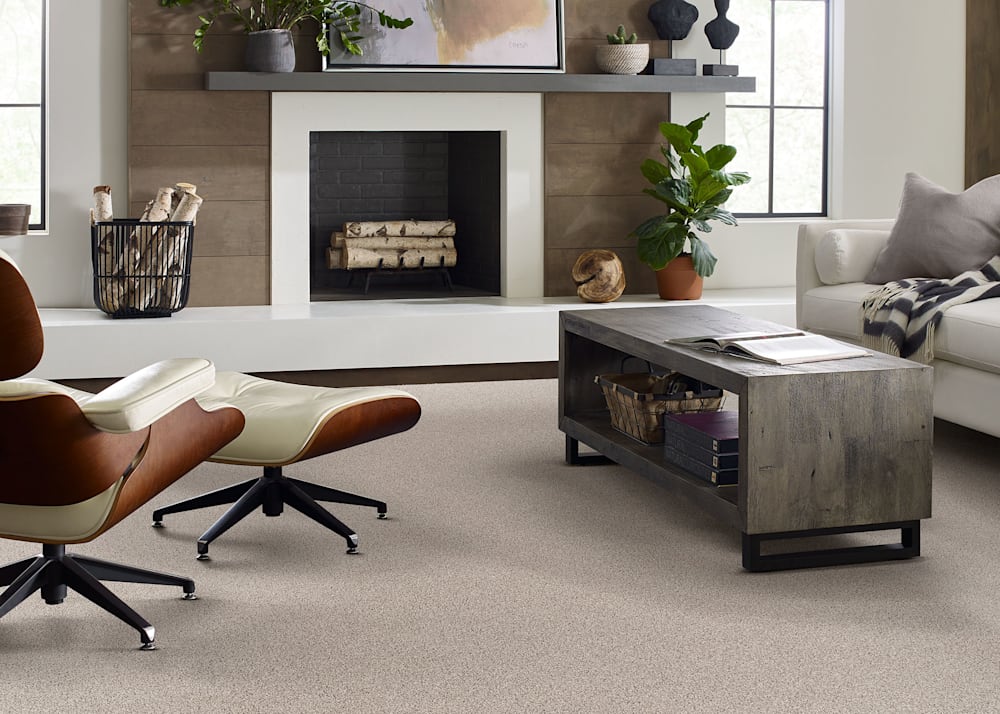 County Kent Carpet in Rock Salt in living room with beige upholstered sofa and dark wood coffee table plus white leather chair and ottoman