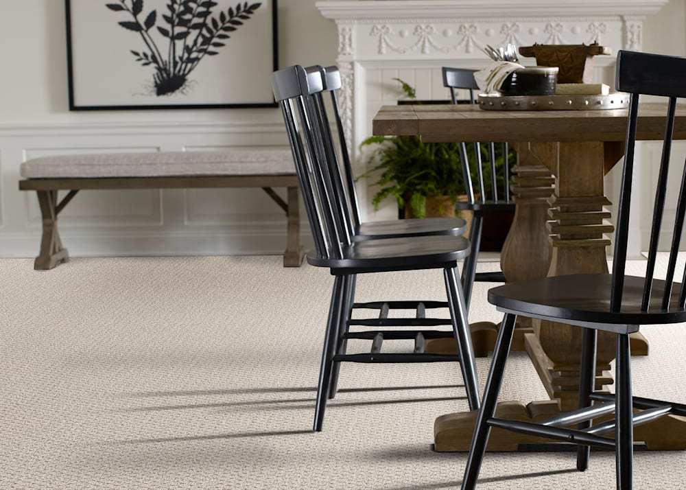 Comstock Cove Carpet in Popcorn in dining room with dark wood table and black spindle chairs plus white fireplace