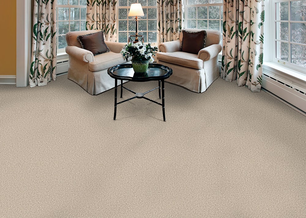 Gardiners Bay Carpet in Blend in living room with matching taupe upholstered armchairs and small round cocktail table plus floral drapes